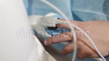 病人`手在手术室的<strong>心率监测</strong>仪。 手术期间病人手指`心电图